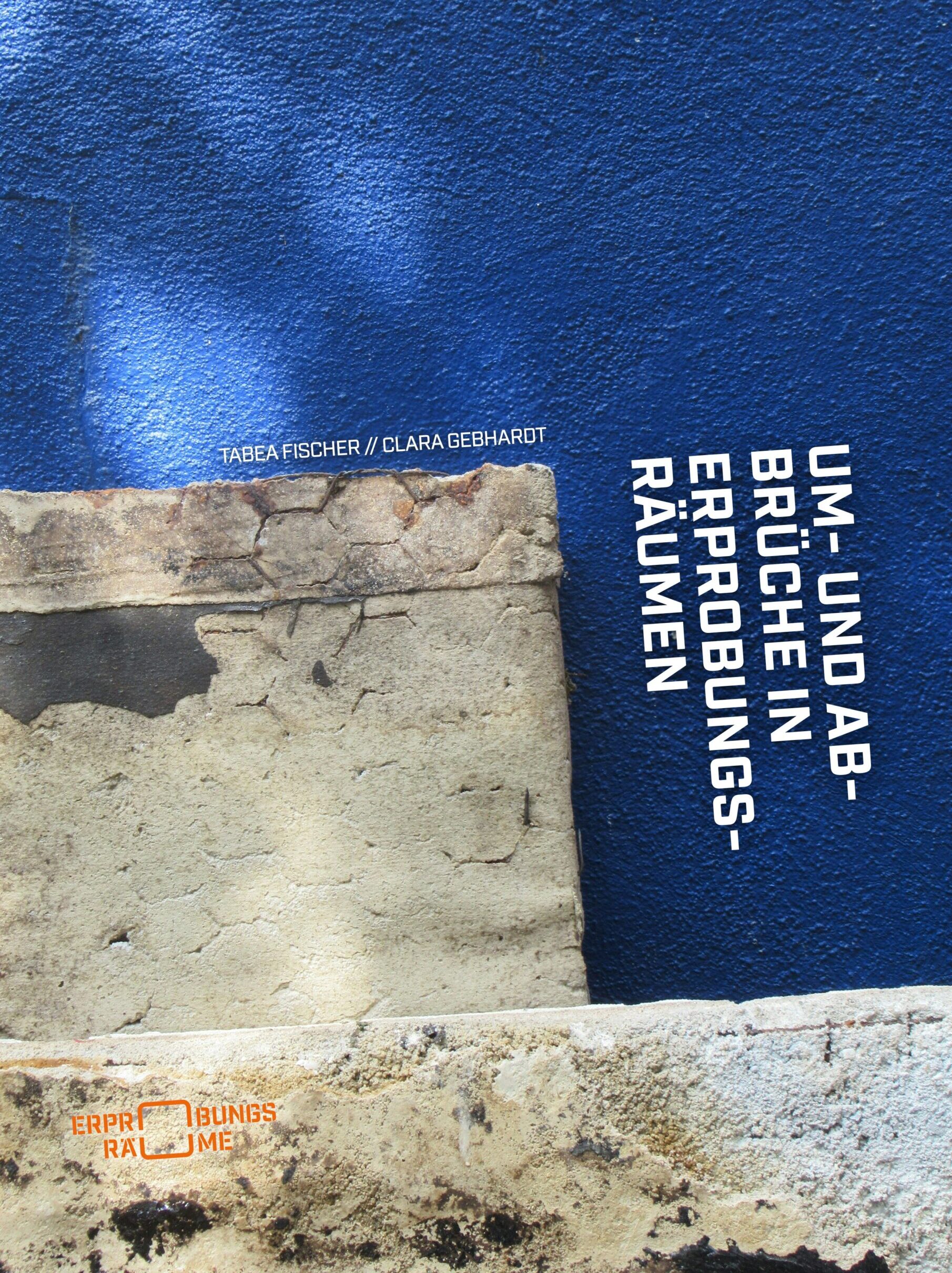 Eine blaue Wand trifft auf eine strukturierte Steinoberfläche. Der vertikal angeordnete deutsche Text lautet: „Um- und Abbrüche in Erprobungsräumen“. Autorinnen: Tabea Fischer, Clara Gebhardt.